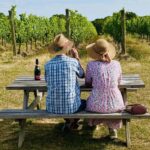 Woodchurch Wine Estate couple on a bench in hats