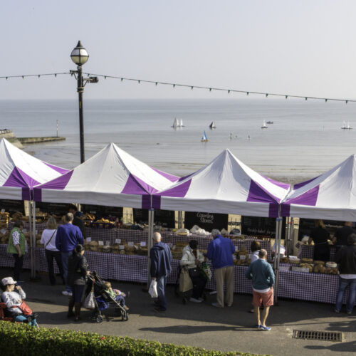 Broadstairs Food Festival purple and white stalls bay in background credit Thanet Tourism
