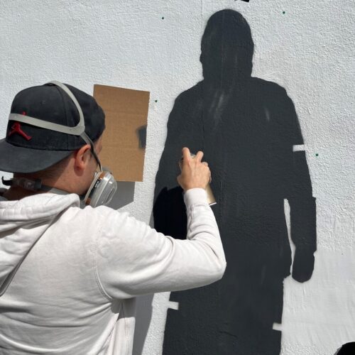 Catman at work on his street art designs Shepherd Neame Whitstable Bay