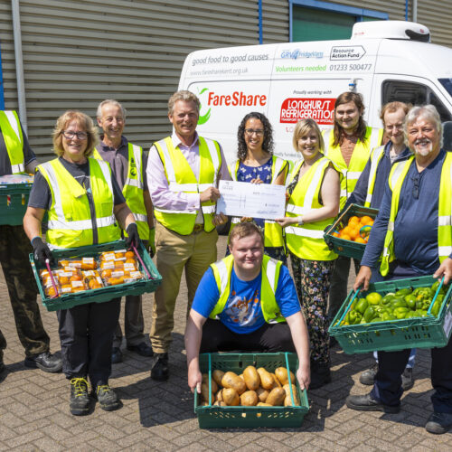 Jonathan Neame presents a cheque Emma White and Kirsty Ford at Fare Shares Ashford warehouse